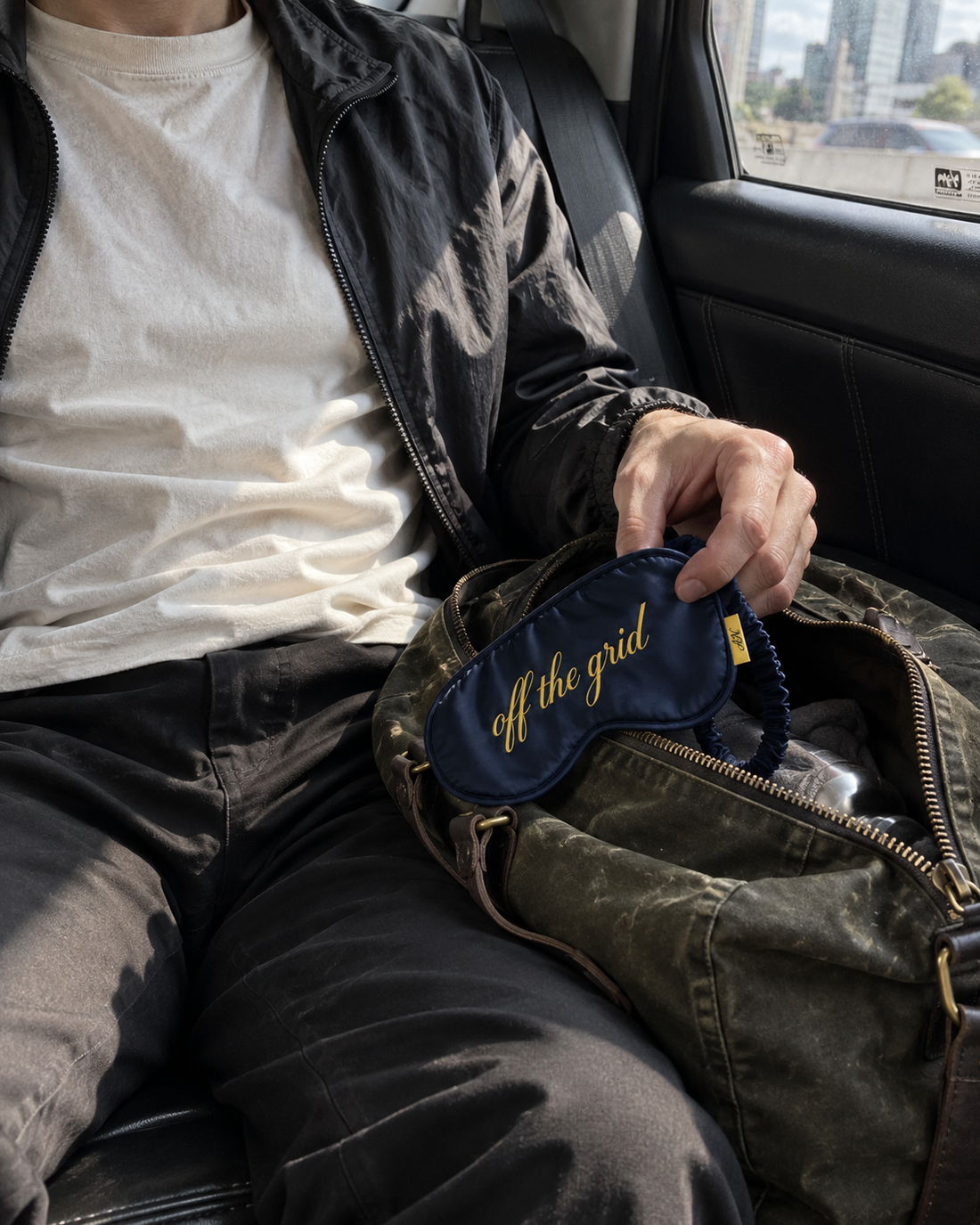 Off the grid sleep mask being taken from a travel bag in a taxi · AI-generated lifestyle image