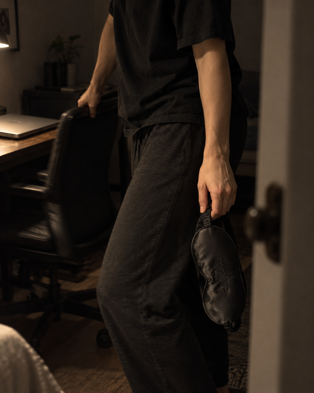 NOX sleep mask carried while leaving the desk at night · AI-generated lifestyle image
